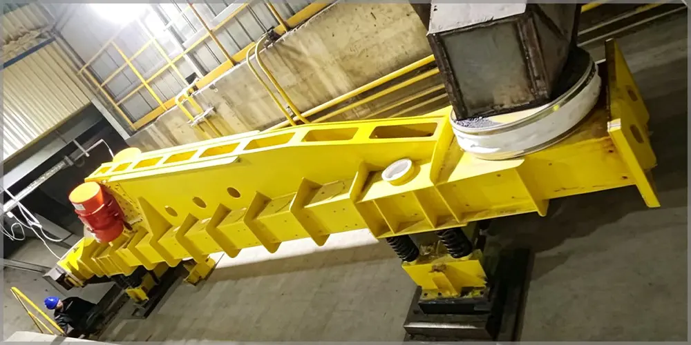 Heavy-duty vibrating conveyor installed on industrial site, robust vibratory conveying machine for high-capacity bulk solids conveying
